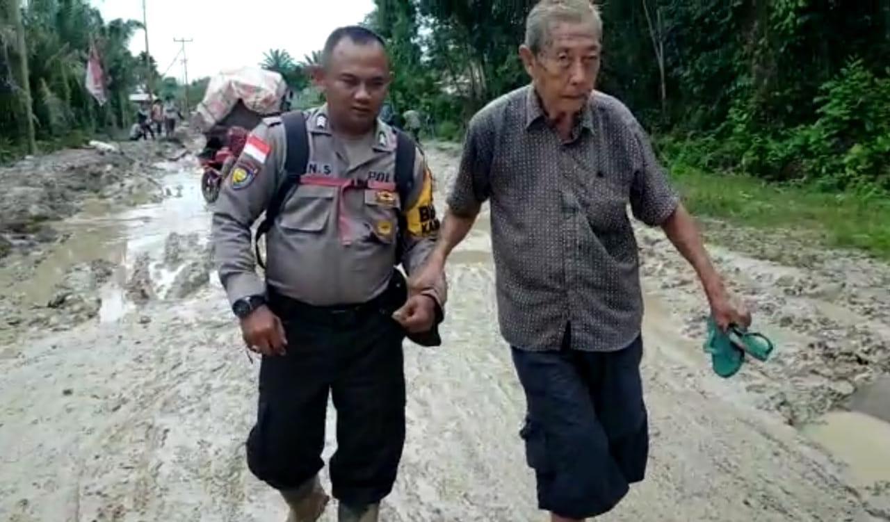 Personil Polsek Rupat Utara Bantu Masyarakat Melintasi Jalan Poros Di Desa Kadur Yang Rusak Parah